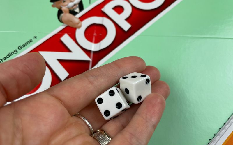 Dice being rolled in a game of Monopoly
