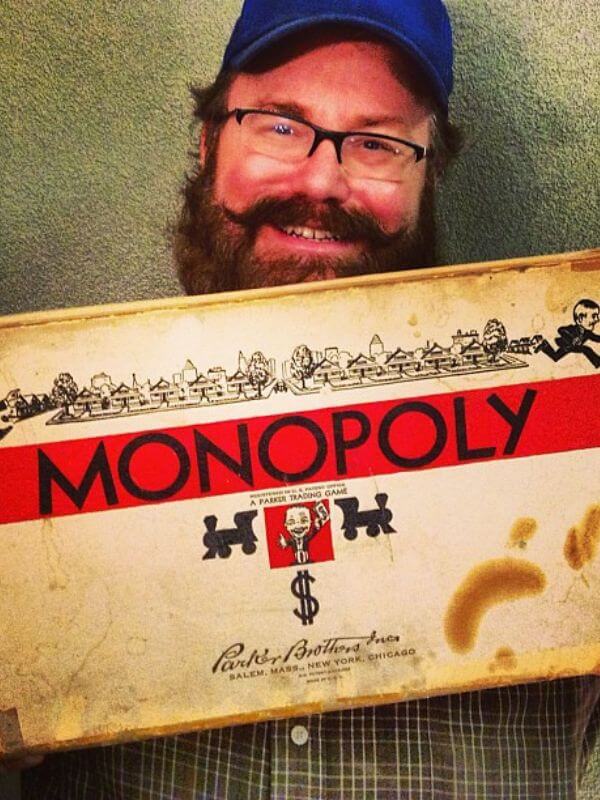 Mike Mozart holding a Parker Brothers Monopoly game